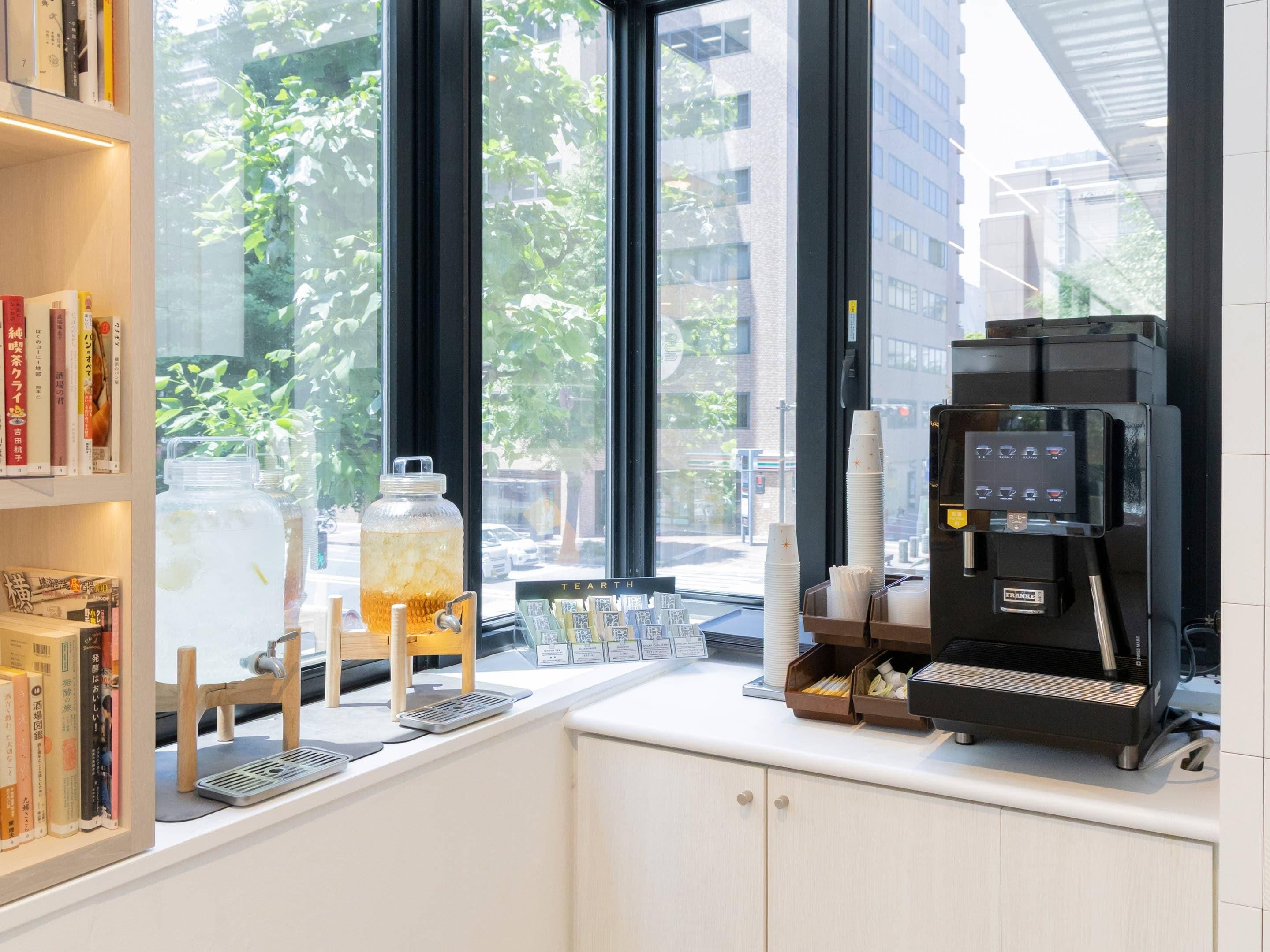 A coffee shop interior with a coffee machine, a large window, and bookshelves.