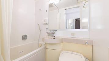 A bathroom with a bathtub, sink, mirror, and toilet.