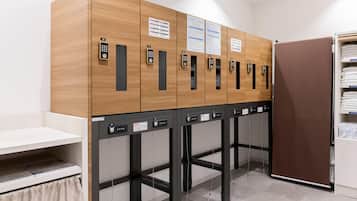 A row of lockers with numbered keys, a white counter, and a brown door.