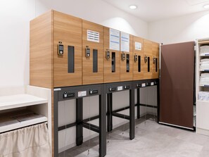 A row of lockers with numbered keys, a white counter, and a brown door. - Comfort Hotel Yokohama Kannai (Yokohama)
