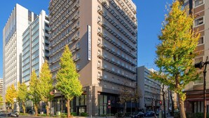 A multi-story hotel with a modern design, featuring a prominent corner entrance and multiple balconies. - Comfort Hotel Yokohama Kannai (Yokohama)