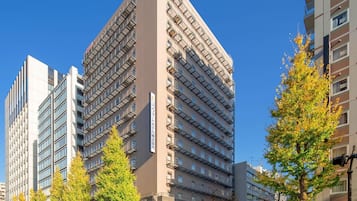A multi-story hotel with a modern design, featuring a prominent corner entrance and multiple balconies.