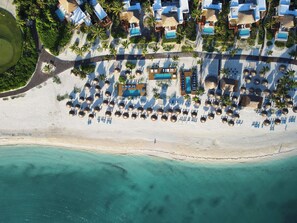 An aerial view of a beach resort with multiple swimming pools, sun loungers, and a sandy beach. - Fairmont Mayakoba  (Playa del Carmen)