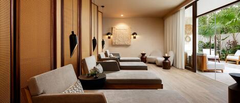A modern interior with a seating area featuring sofas and a large window offering a view of greenery outside.