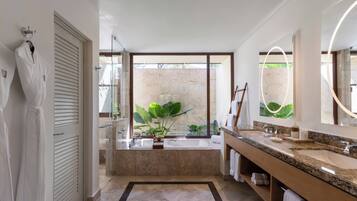 Un baño moderno con un ventanal grande, una bañera y un tocador con espejo.