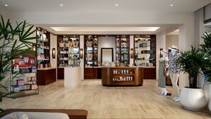 Un espacio comercial moderno con estanterías de madera, un mostrador central y un maniquí.
