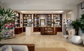 Un espace de vente moderne, doté d’étagères en bois, d’un comptoir central et d’un mannequin.