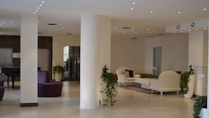 A spacious lobby with a piano, modern seating, and potted plants. - Hotel Lugano Torretta (Mestre)