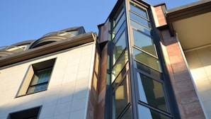 A modern building with a corner entrance, large windows, and a curved architectural feature above the entrance. - Hotel Lugano Torretta (Mestre)