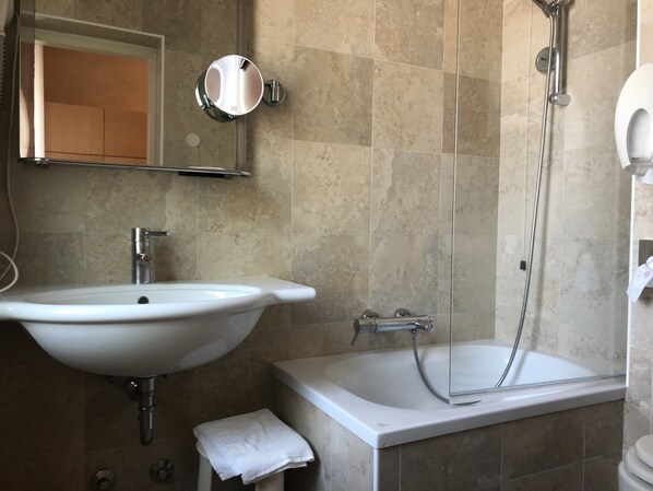 A bathroom with a sink, mirror, and bathtub. - Hotel Lugano Torretta (Mestre)