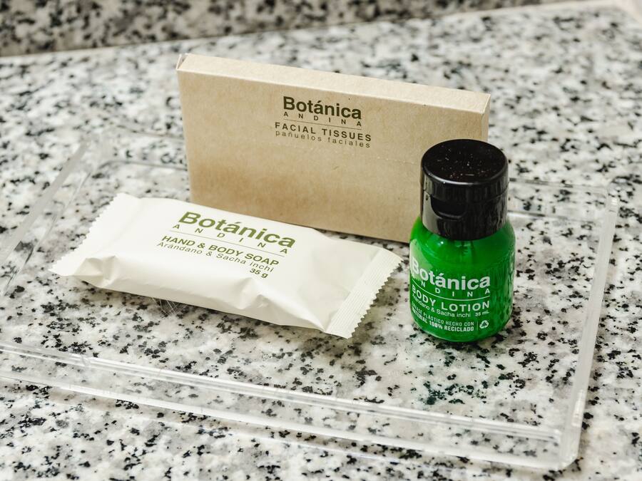 Eine Packung Botanica Hand- und Körperseife, eine Flasche Botanica Körperlotion und eine Schachtel Botanica Taschentücher auf einer Granit Arbeitsplatte.