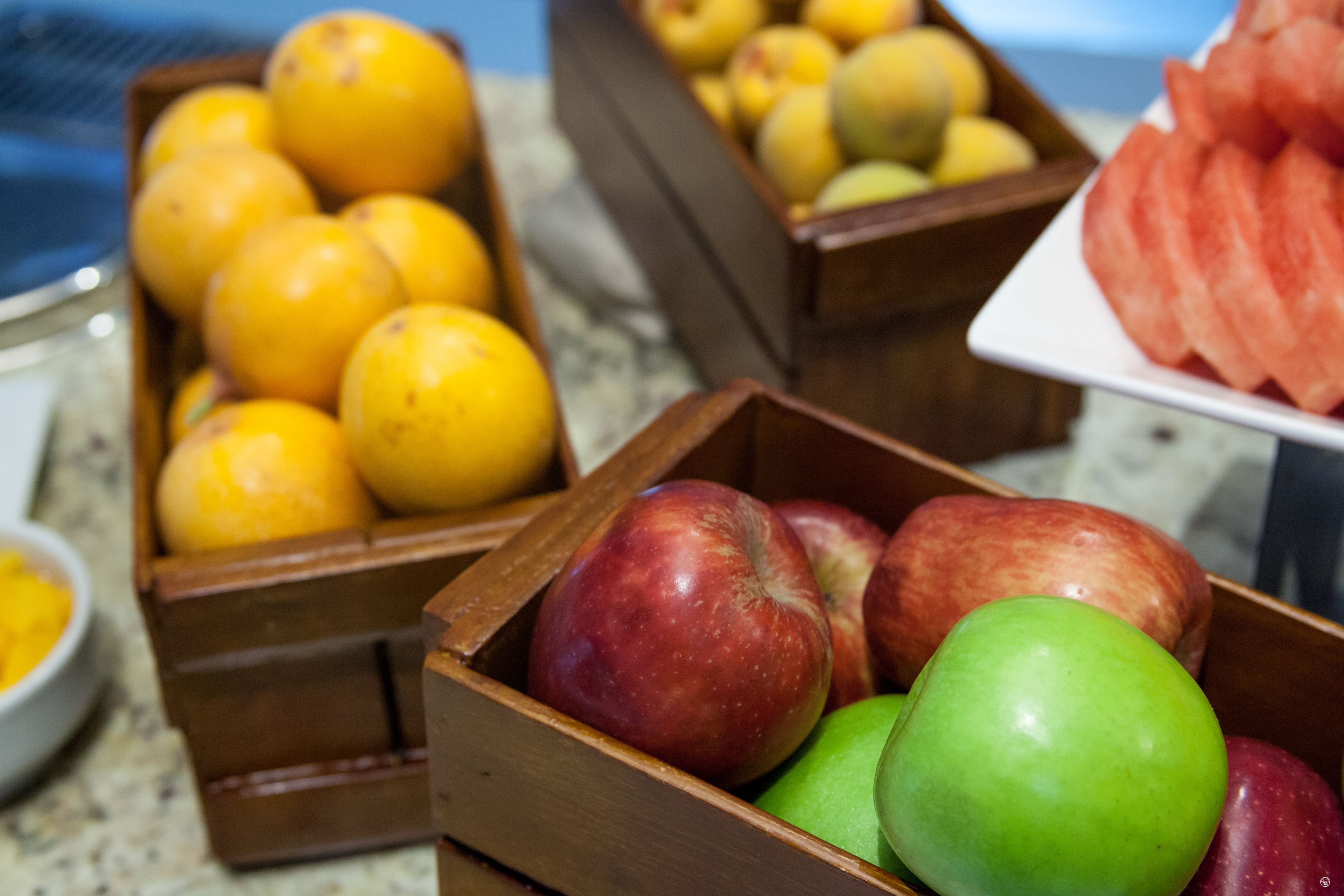 Casse di legno piene di frutta assortita, tra cui mele e arance.