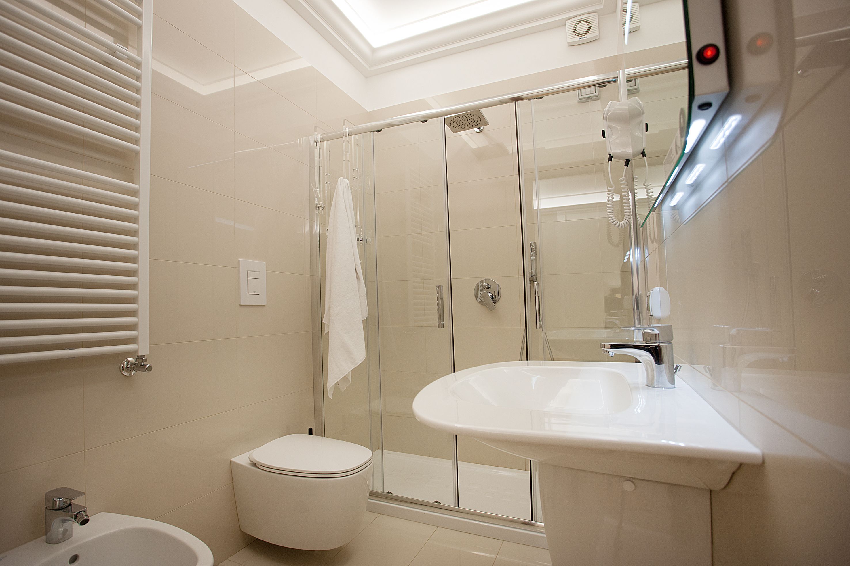 A modern bathroom with a glass shower enclosure, a white sink, and a toilet.
