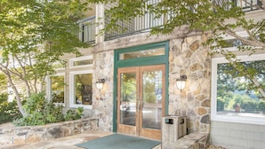 A stone building with a green door, a stone staircase, and a stone patio. - Lake Chatuge Lodge (Hiawassee)