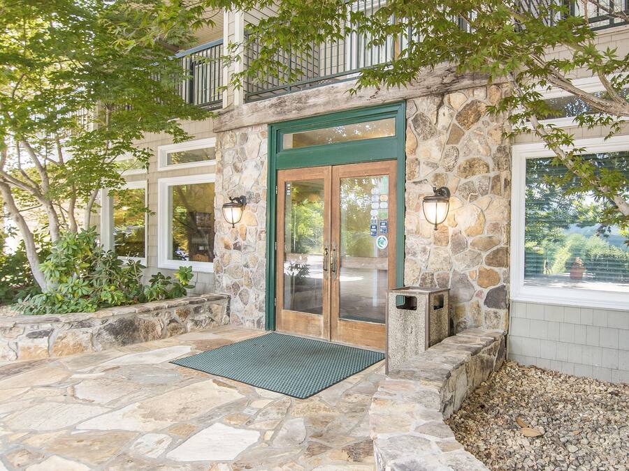 A stone building with a green door, a stone staircase, and a stone patio.