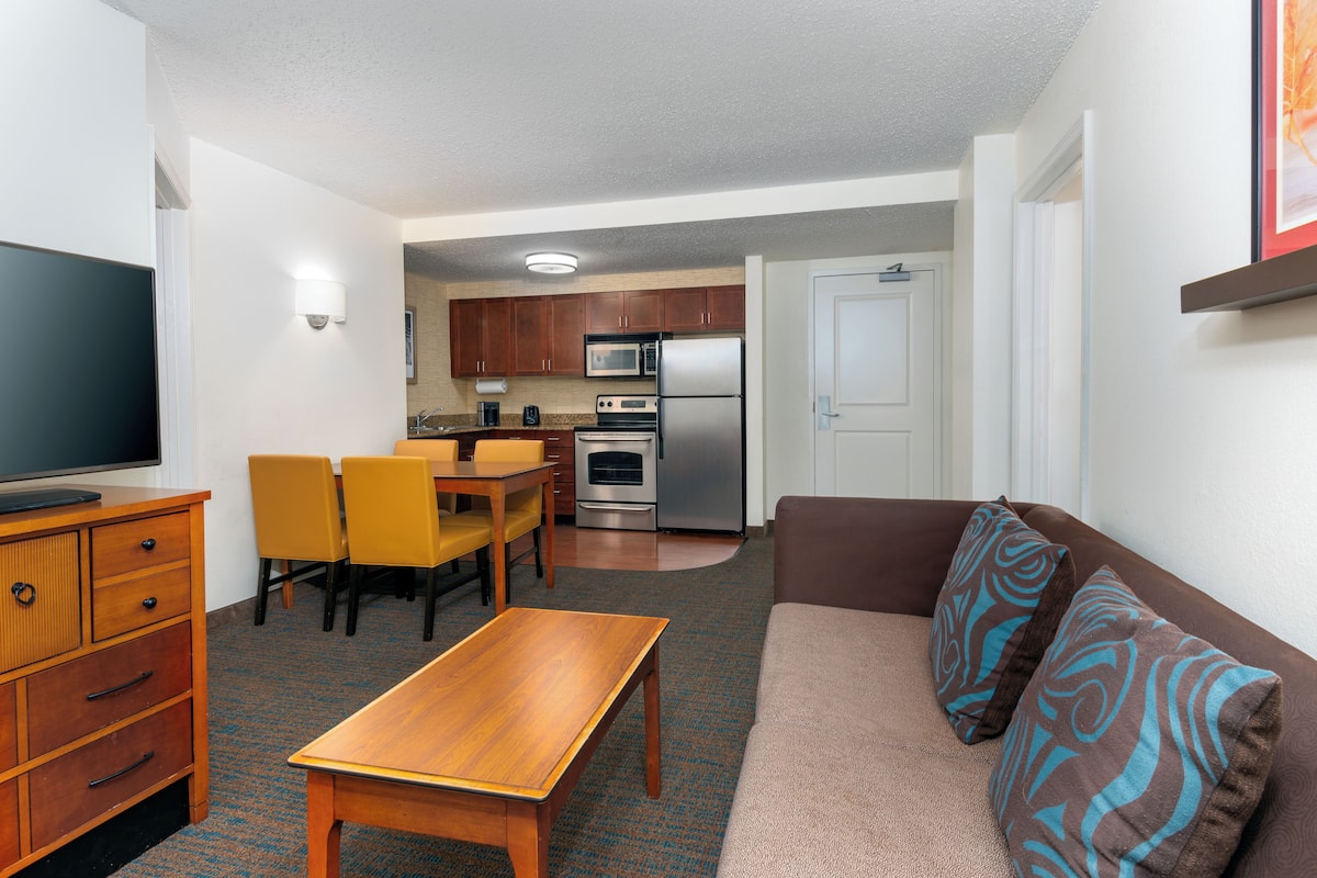 A compact living space with a kitchenette, a dining area, and a seating area.