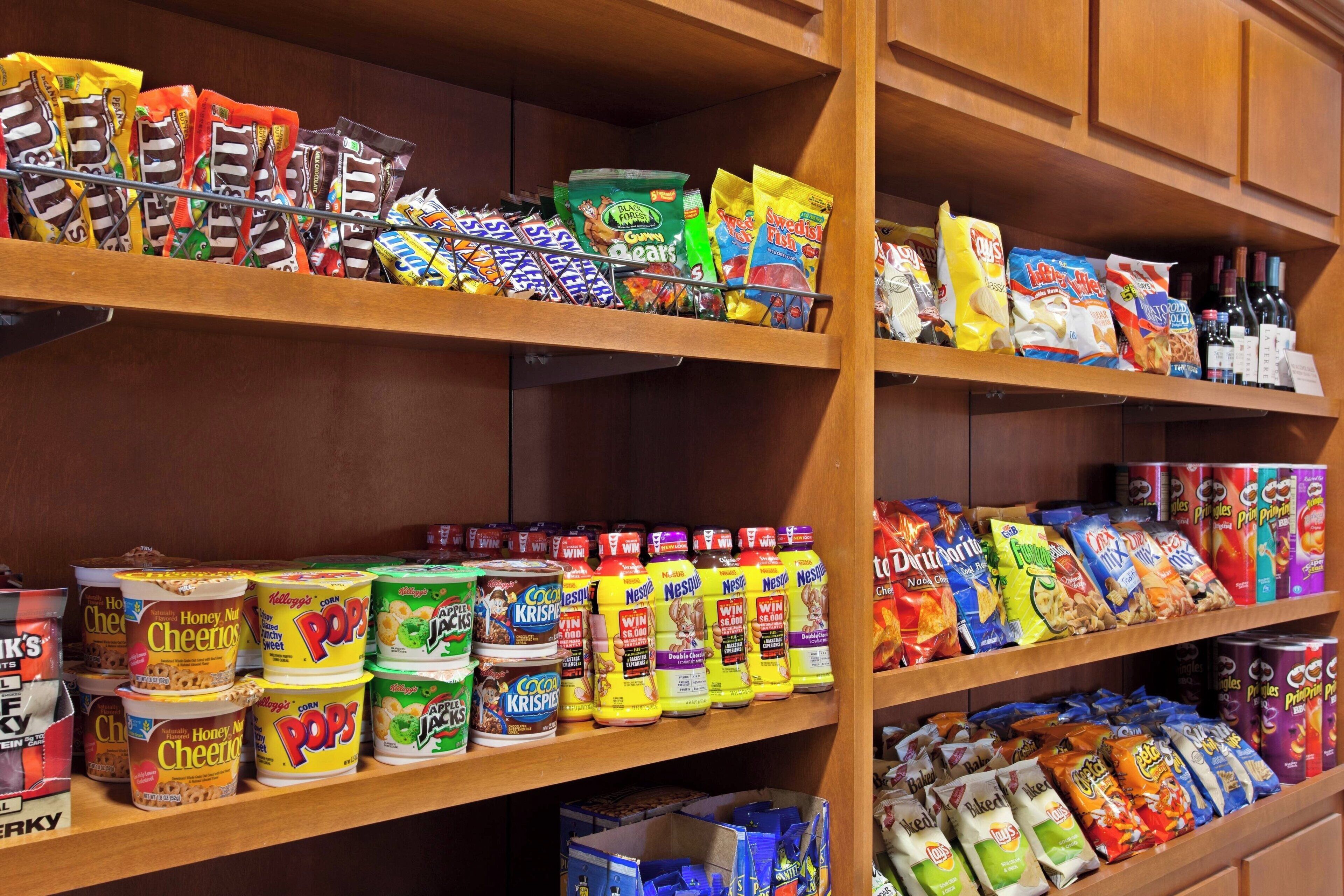 Shelves stocked with various snacks and cereals.