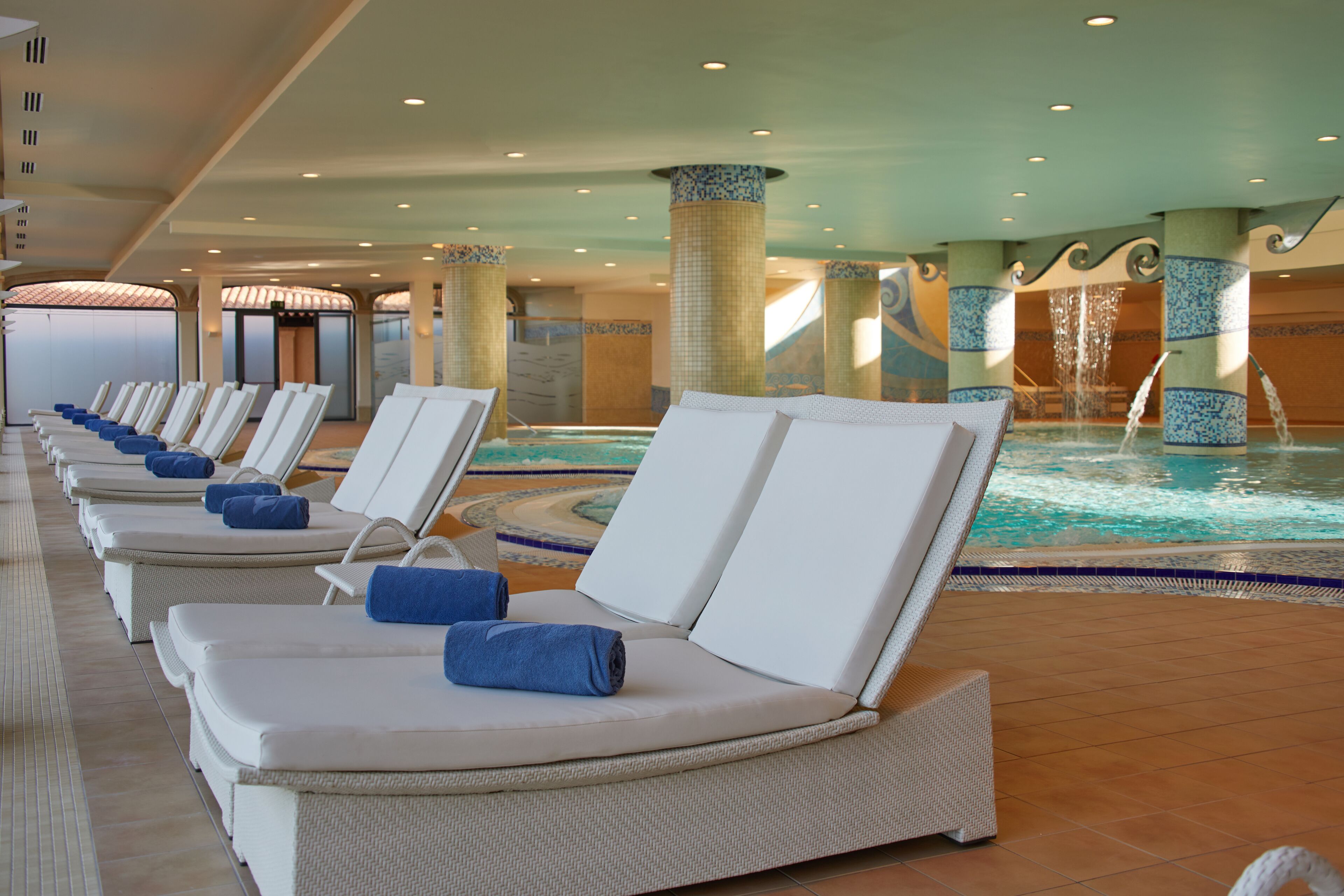 Zona junto a la piscina con sillones de descanso y jacuzzi.