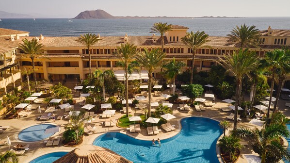 Alberca techada, 2 albercas al aire libre y sombrillas en la alberca