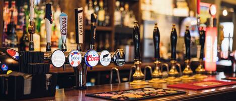 Un bar con varias griferías de cerveza, incluyendo marcas como Coors y Guinness.