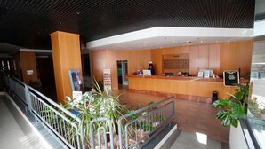 A hotel reception area with a marble counter, a receptionist, and a reception desk. - Classic Hotel Tulipano (Terni)