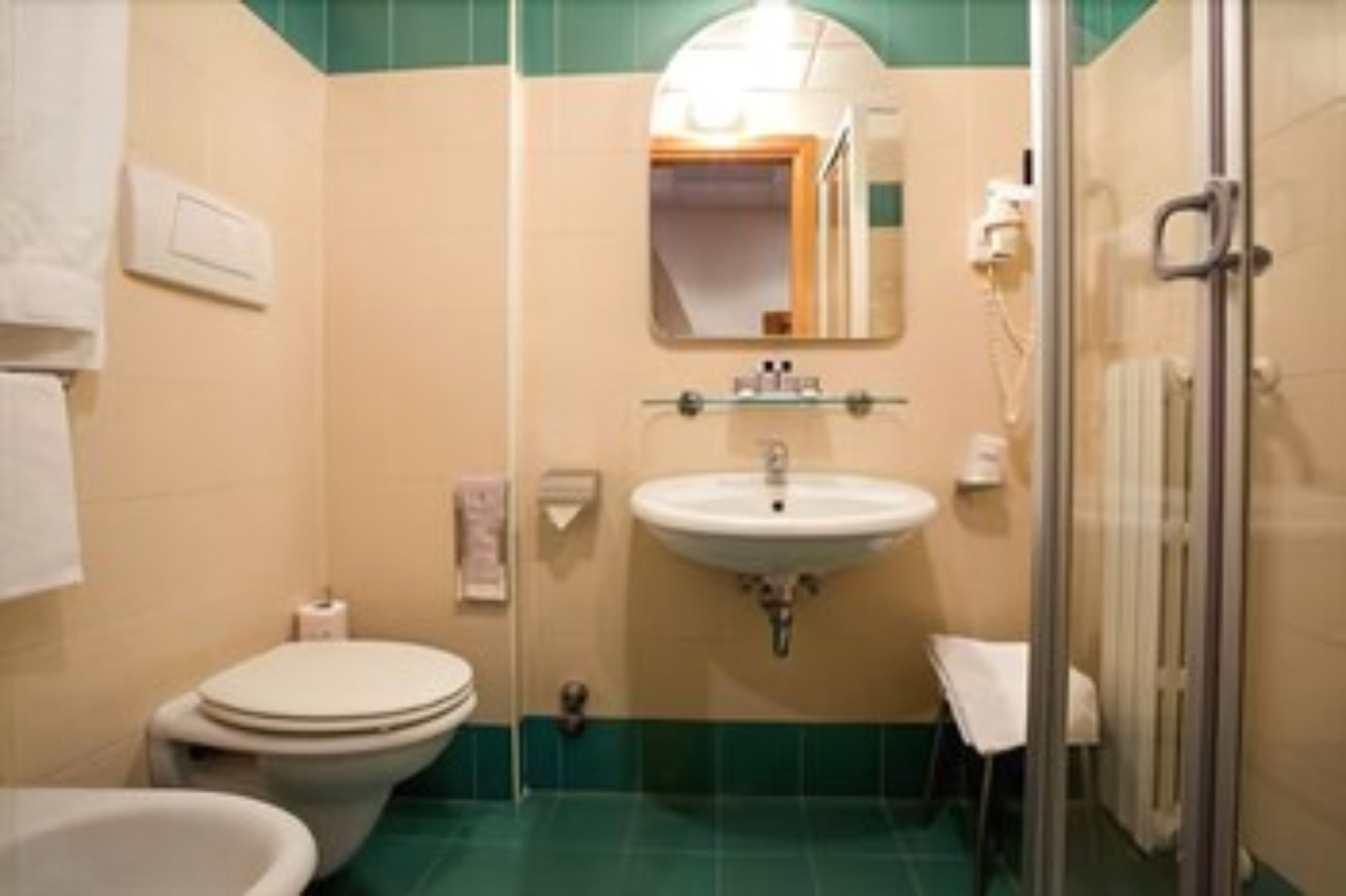 A bathroom with a toilet, sink, and shower.
