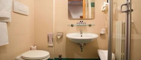 A bathroom with a toilet, sink, and shower.