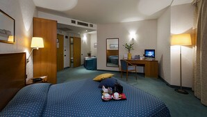 A hotel room with a bed, desk, chair, and a small table with a plant. - Classic Hotel Tulipano (Terni)