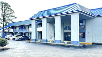 Stylish entrance with a covered area supported by columns, offering a convenient parking space.
