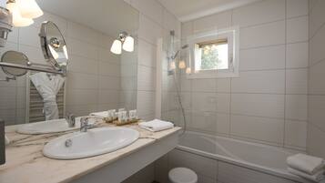 Un baño moderno con dos lavamanos, un espejo grande, una ducha y un taburete pequeño.