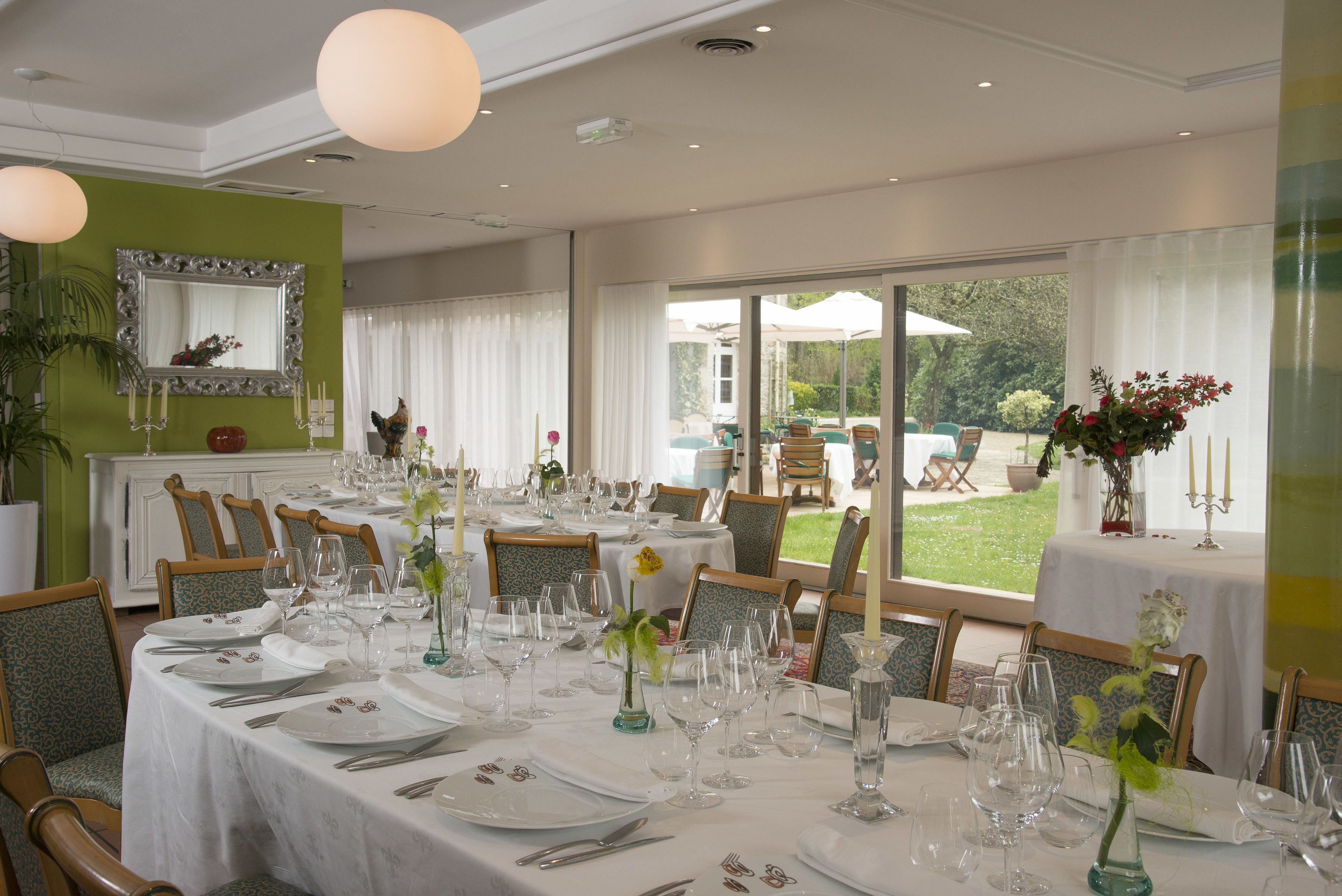 A dining area with tables set for a meal, chairs, and a view of the outdoors.