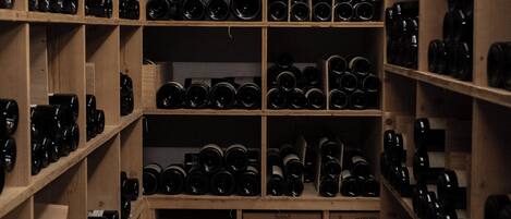 Une cave à vin avec des étagères en bois remplies de bouteilles de vin.