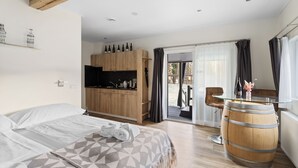 A bedroom with a bed, a wooden wardrobe, a glass table, and a barrel.
