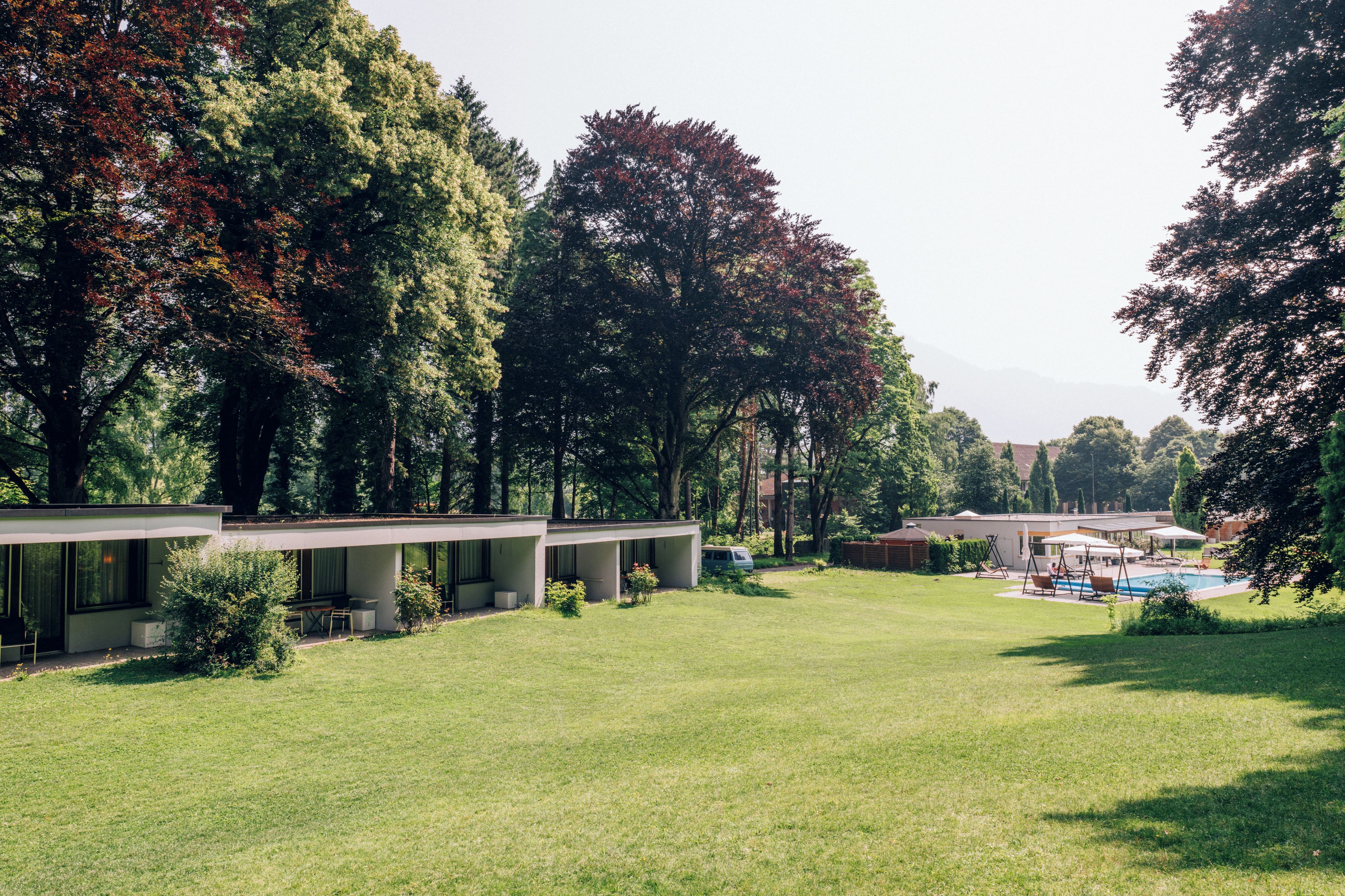 A modern building with a covered outdoor seating area and a swimming pool.