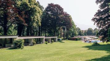 A modern building with a covered outdoor seating area and a swimming pool.