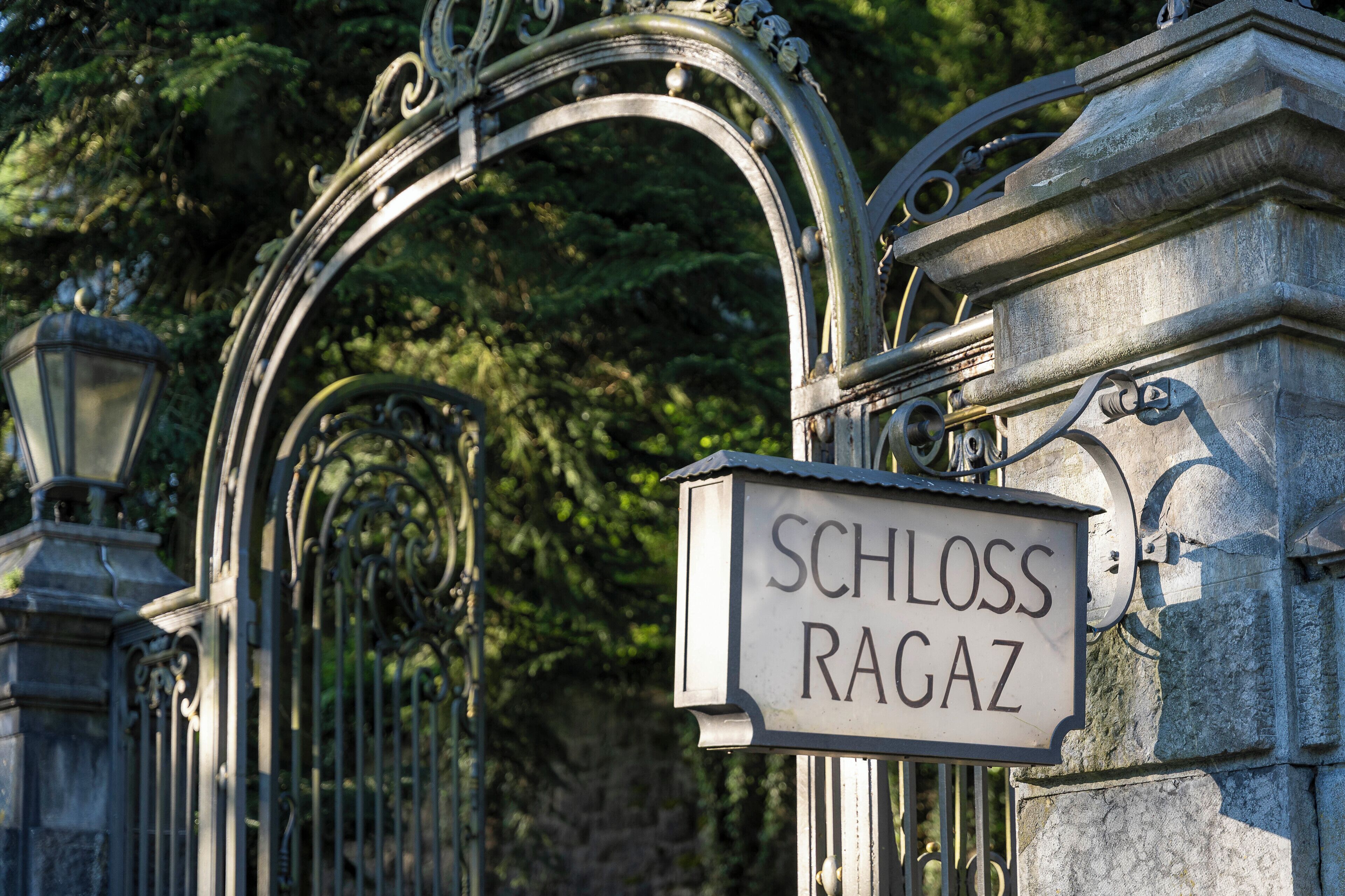 A wrought iron gate with a sign reading "SCHLOSS RAGAZ."