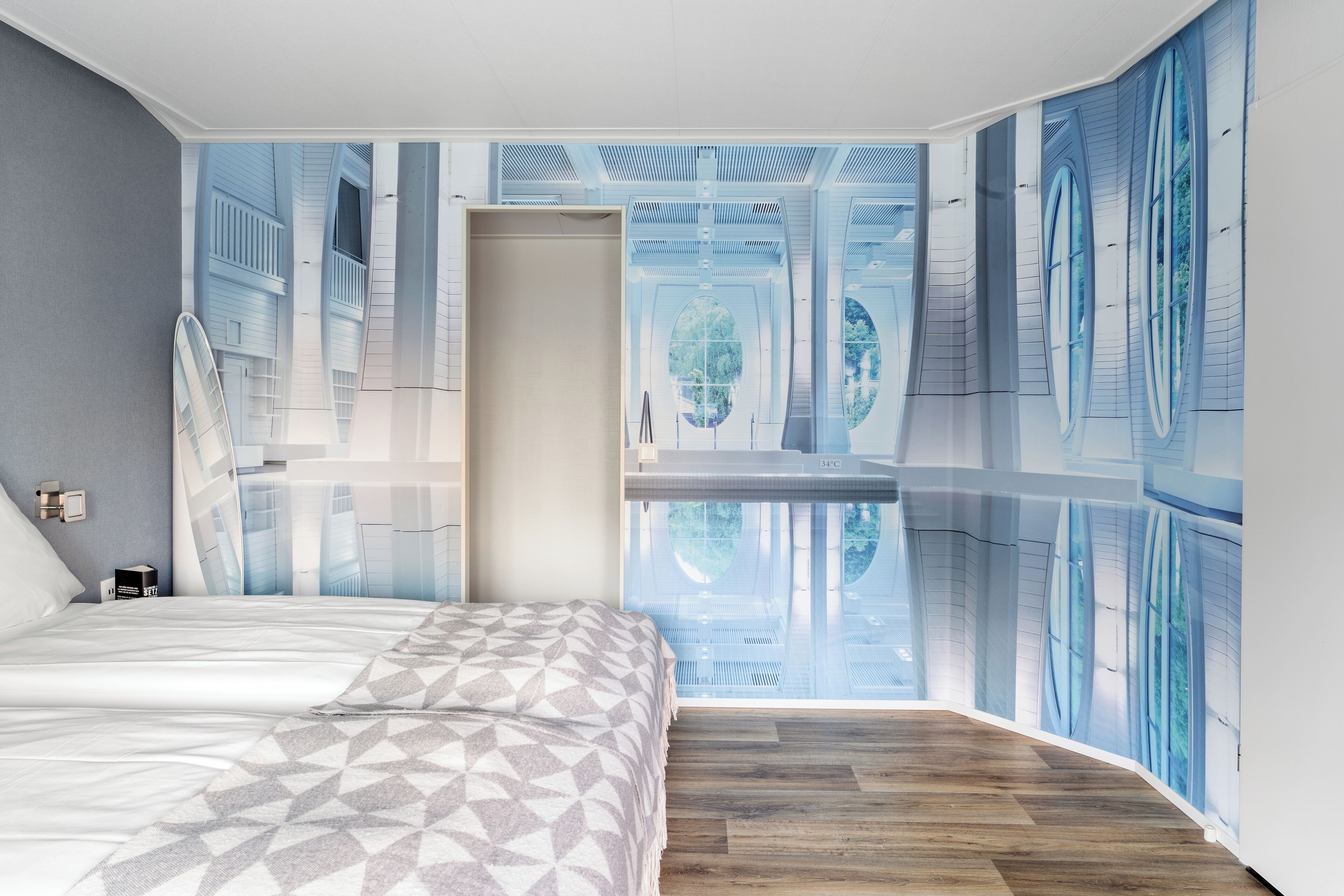 A modern bedroom with a large bed, a view of a balcony, and a unique wall design.
