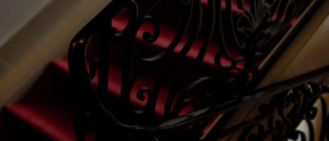 A close-up of a black wrought iron staircase railing with intricate designs.