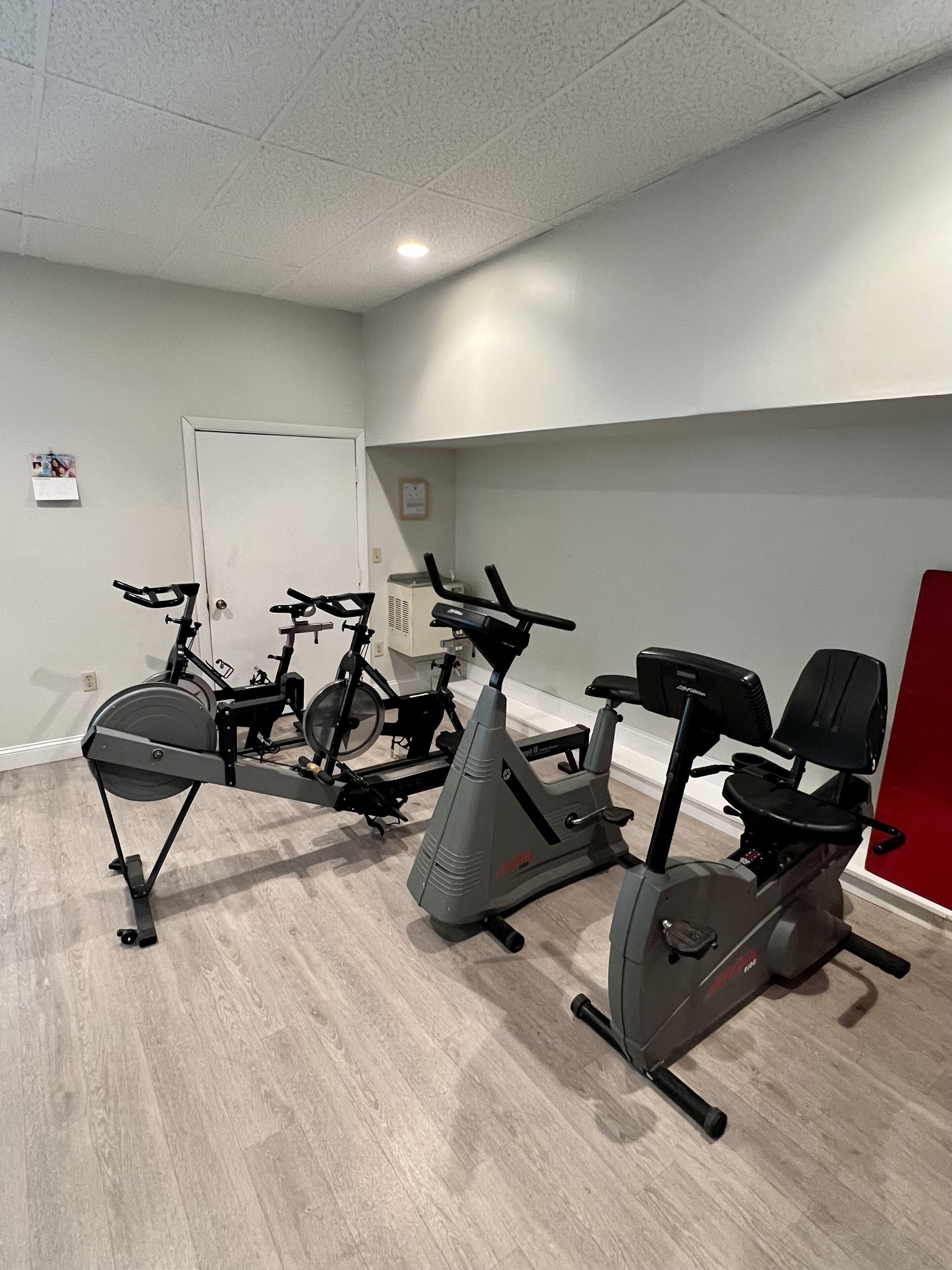 A fitness room with stationary bikes and an elliptical machine.
