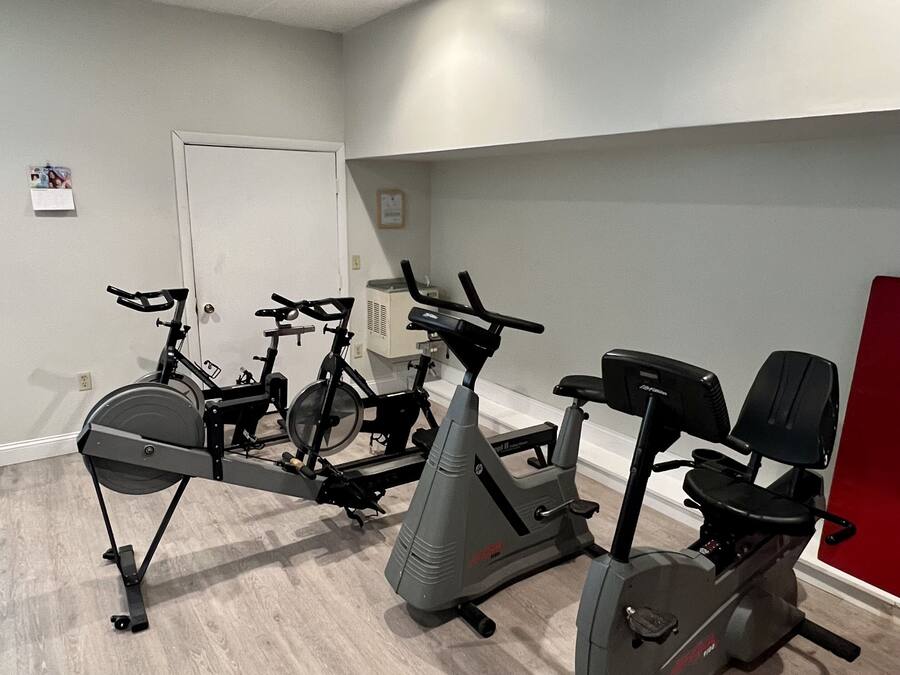 A fitness room with stationary bikes and an elliptical machine.