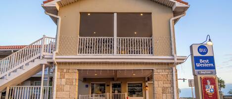 A two-story building with a balcony, a staircase, and a sign reading "Best Western Bayfront."