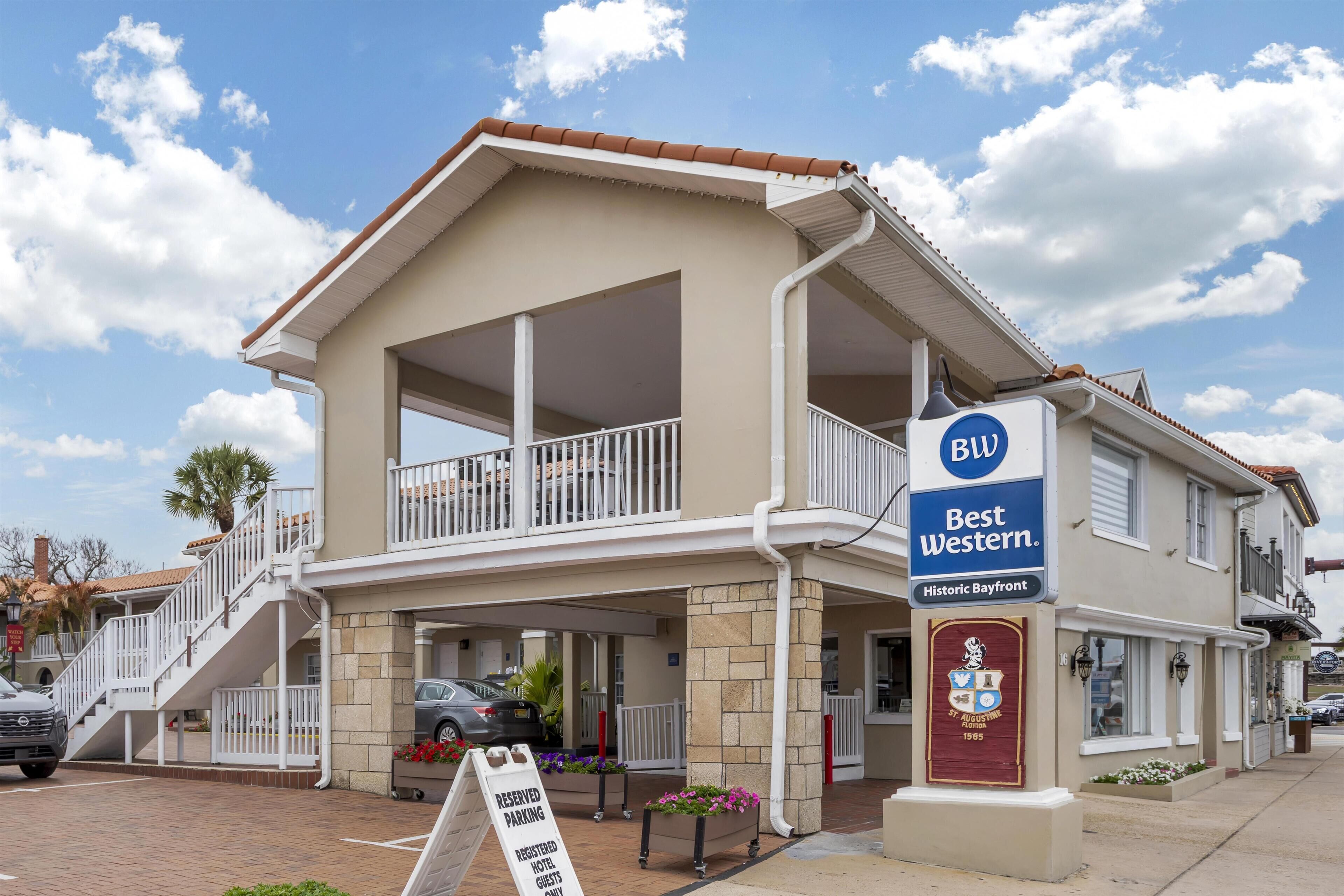 A two-story hotel with a balcony, a sign for Best Western, and a reserved parking sign.