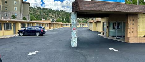 A West Inn motel with a parking lot, a blue sign, and a row of motel rooms.
