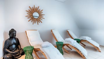 Relax in a serene spa room with a large mirror, comfortable lounge chairs, and a tranquil atmosphere.