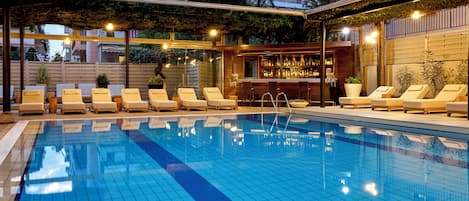 Una piscina al aire libre de temporada, sillones reclinables de piscina