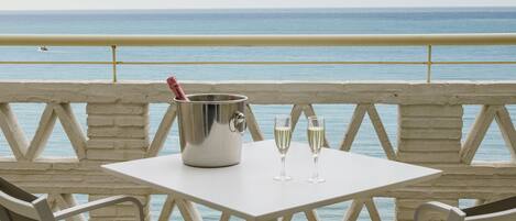 A table with a champagne bucket and glasses, overlooking the sea.