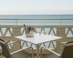 A table with a champagne bucket and glasses, overlooking the sea.