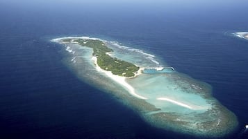 Na praia, areia branca, espreguiçadeiras, guarda-sóis