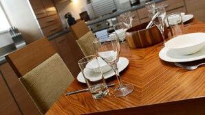 A dining table set with plates, glasses, and cutlery in a modern kitchen. - PREMIER SUITES Newcastle (Newcastle-upon-Tyne)