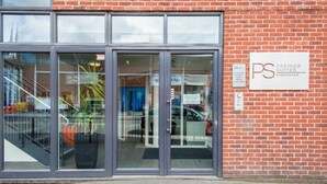 Hotellin sisäänkäynti, jossa on lasiovet ja kyltti, jossa lukee Premier Suites Birmingham.